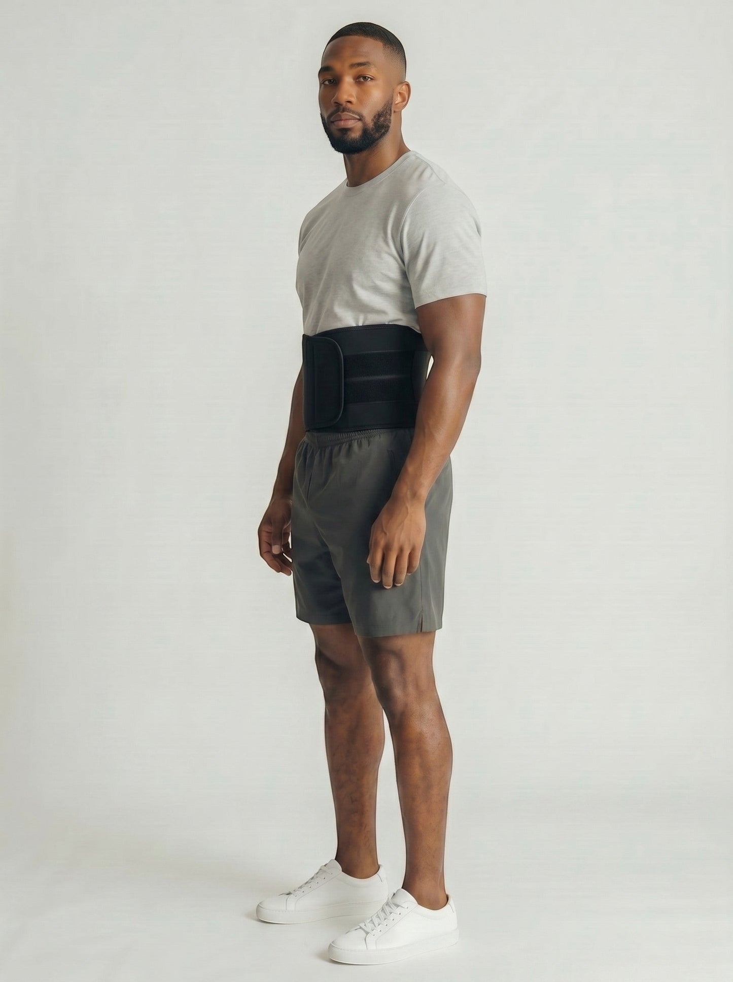 Man wearing a black ThermoCore waist trimmer belt over grey athletic shorts and a t-shirt for core support